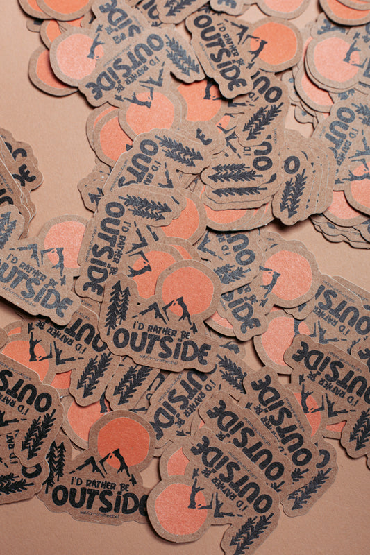 Sticker "I'd rather be outside" auf Kraftpapier.