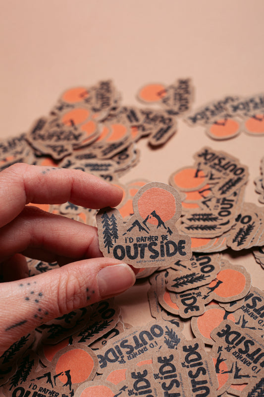 Sticker "I'd rather be outside" auf Kraftpapier.